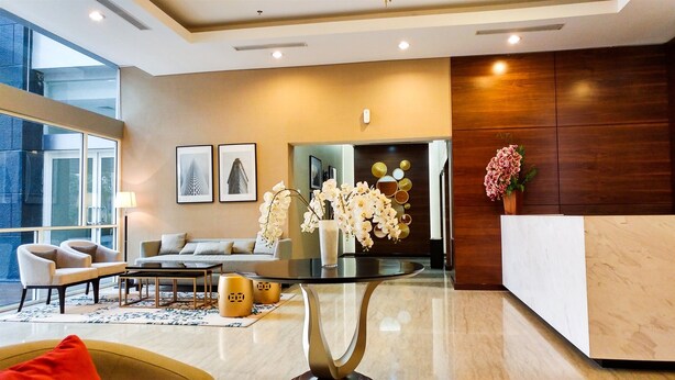 A modern lobby with a glass coffee table, seating area, and a reception desk.