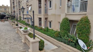 A multi-story residential building with balconies, air conditioning units, and a paved walkway. - Apartment Palazzo/Grand Palace Kemayoran (Jakarta)