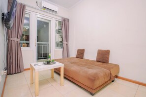 A bedroom with a bed, a small table, and an air conditioning unit. - Apartment Palazzo/Grand Palace Kemayoran (Jakarta)