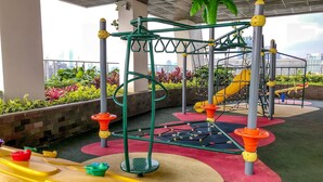 Un espacio de juego al aire libre con estructuras para escalar, toboganes y equipo colorido.