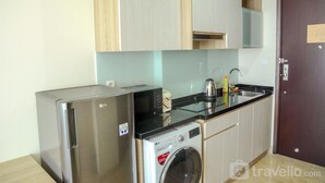 Una cocina compacta equipada con refrigerador, microondas y lavadora.