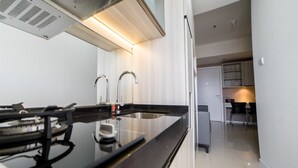 A modern kitchen with a black countertop, stainless steel sink, and a built-in stove.