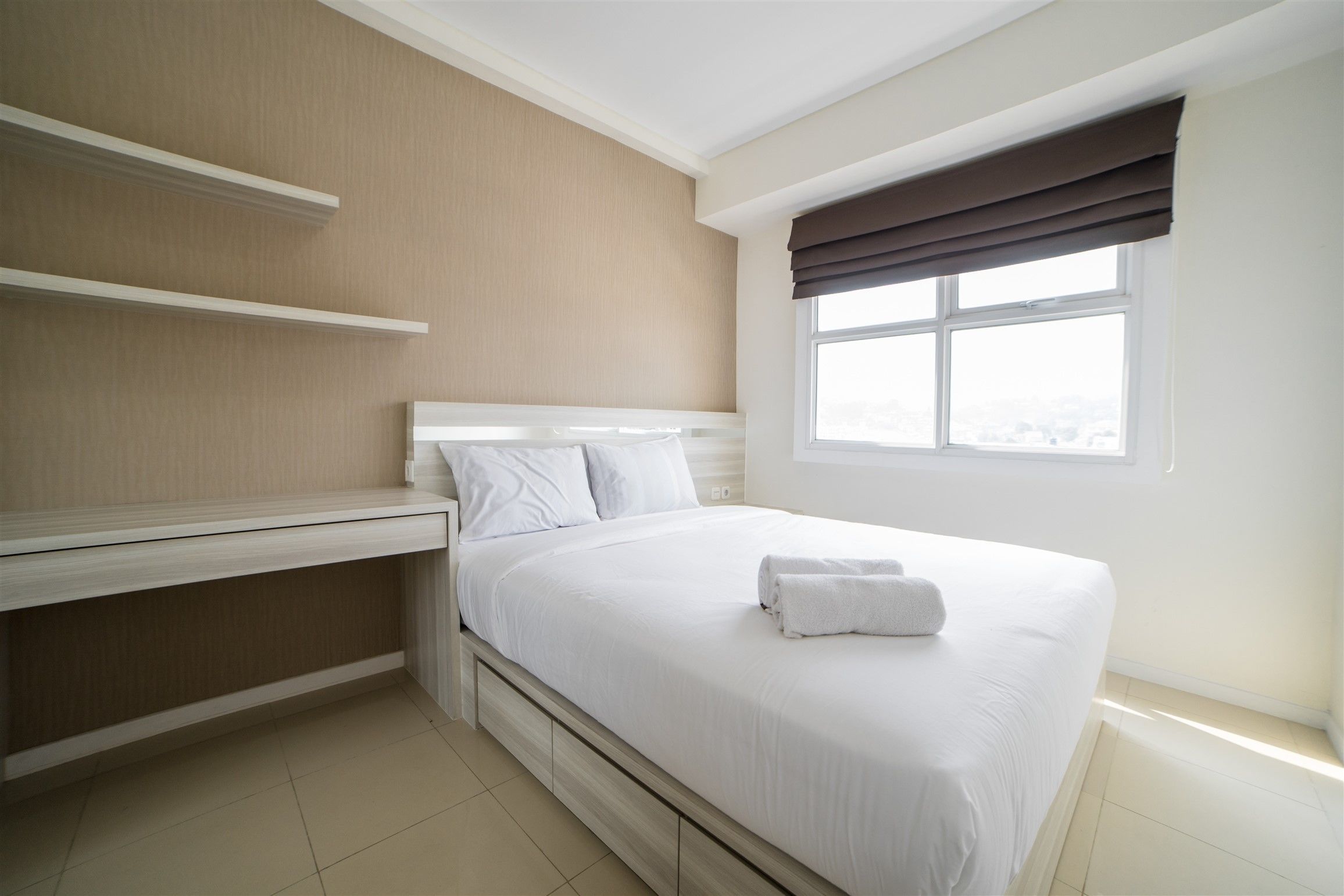 Ein ordentlich eingerichtetes Hotelzimmer mit einem Bett, einem Nachttisch und einem Fenster mit Vorhängen.