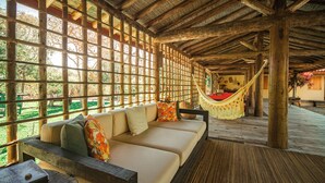 Ein Zimmer mit Holzbalken, einer Couch und einer Hängematte.