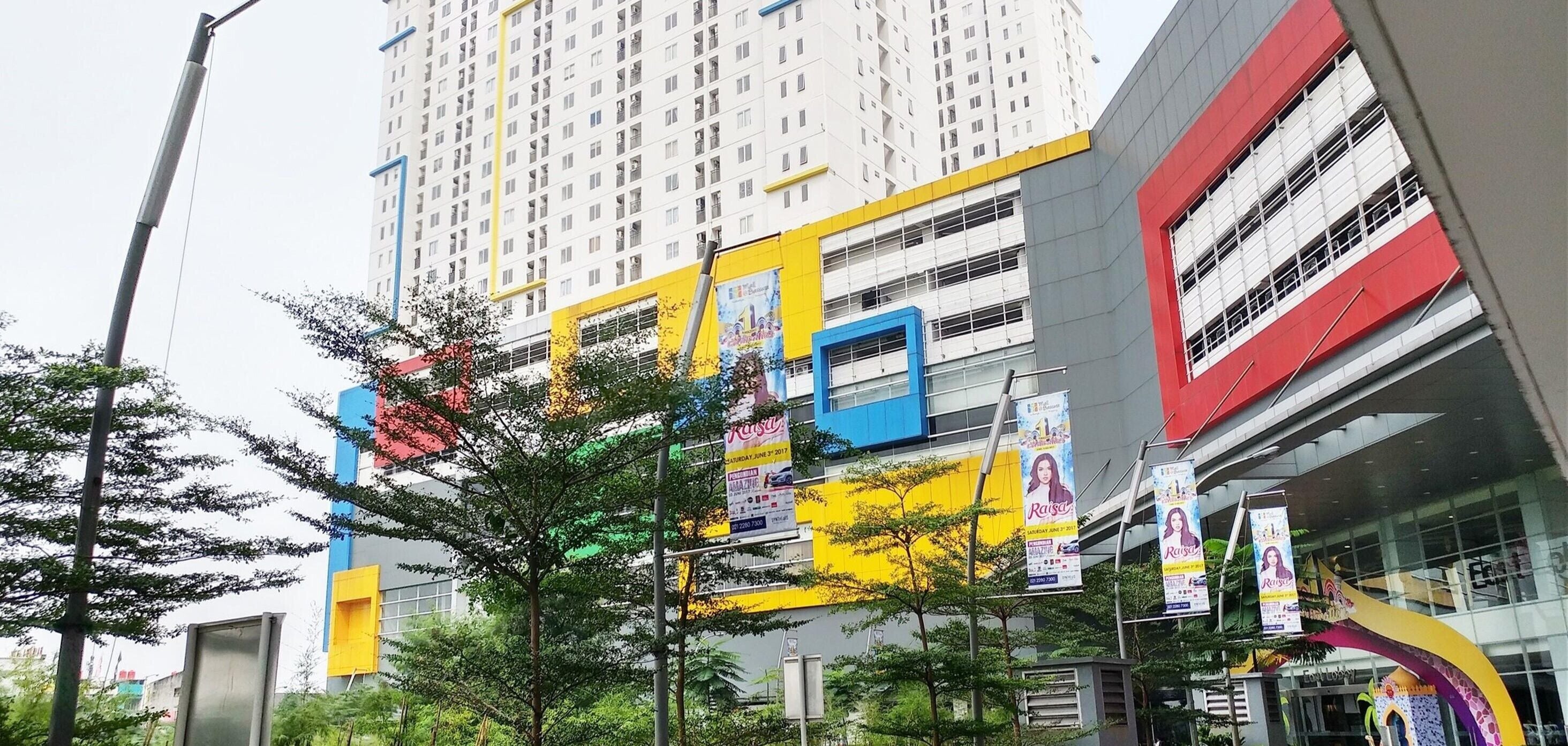 A multi-story building with a modern design, featuring a mix of yellow and red colors on the facade.