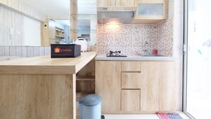 Una cucina moderna con mobili in legno, piano cottura integrato e cappa aspirante con vetro.