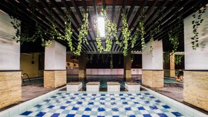 A pool area with checkered tiles, pillars, and hanging greenery. - Best Price Tamansari Panoramic Apartment with Mountain View (Bandung)