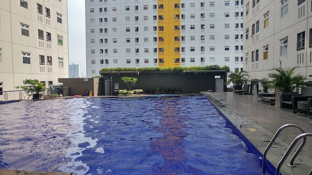 Ein Schwimmbecken mit Blick auf hohe Gebäude im Hintergrund.