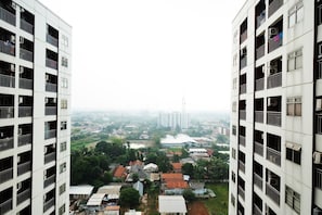 A high-rise building with multiple balconies and air conditioning units.