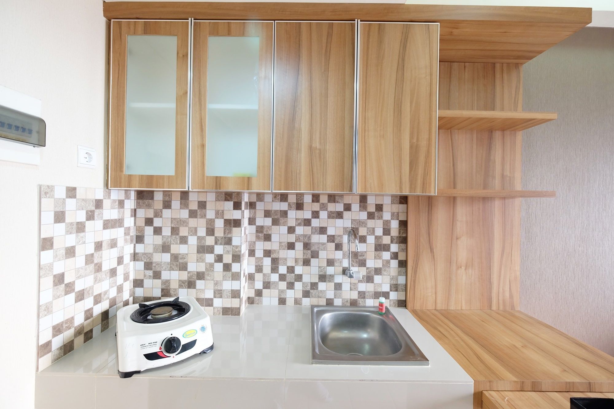 A kitchen with wooden cabinets, a tiled backsplash, a gas stove, and a sink.