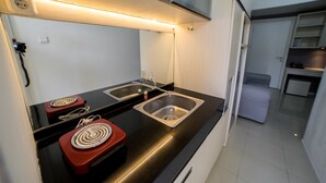 Una cucina moderna con due lavelli, un piano di lavoro nero e un piano cottura a induzione rosso.