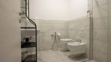 Un baño moderno con cabina de ducha de vidrio, inodoro y lavamanos.