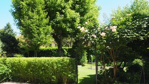 A well-maintained garden with various trees and flowering plants. - Giardino 34 (Forlì)