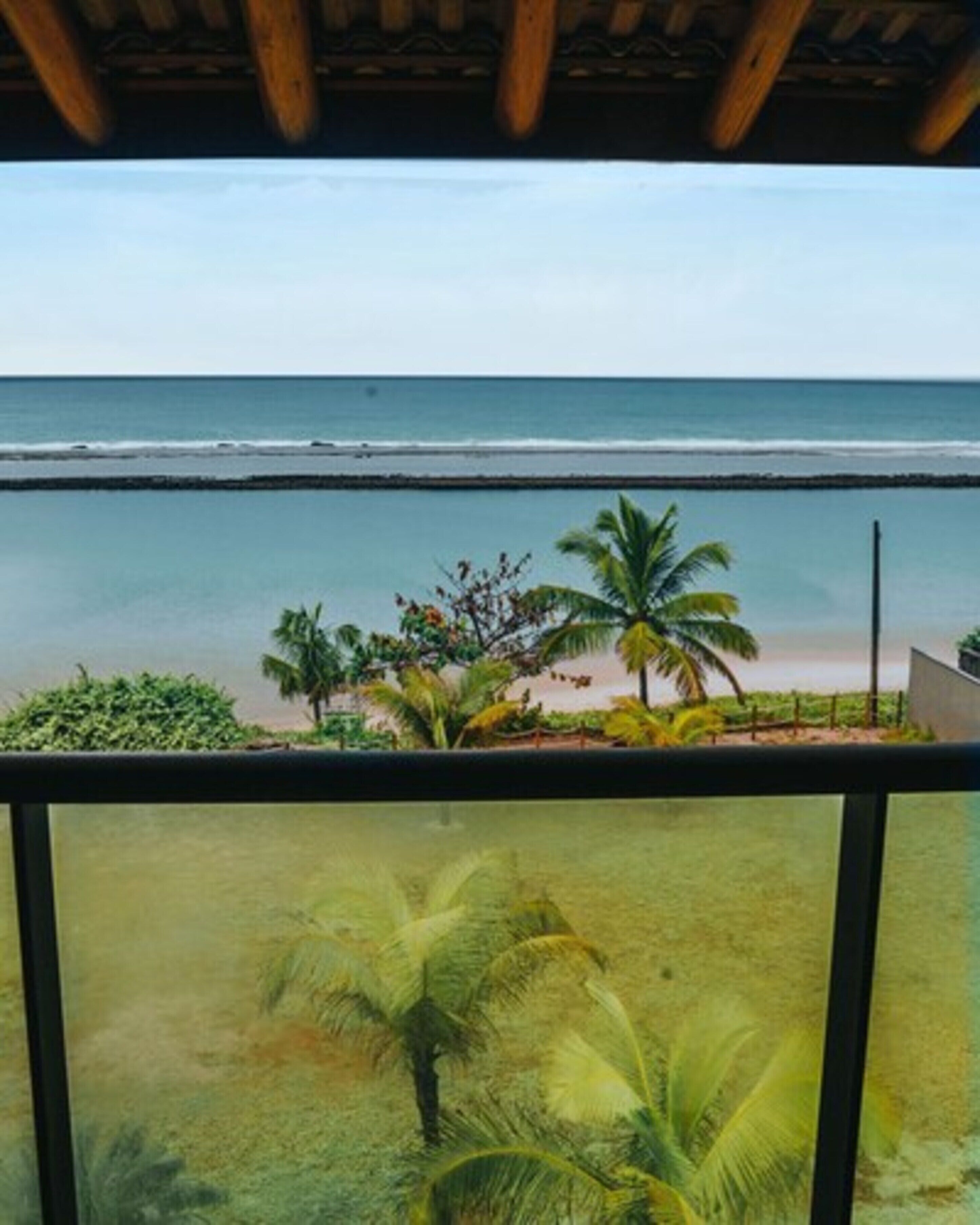 Un balcon avec vue sur une plage et l’océan.