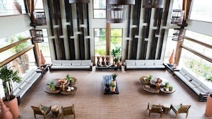 A spacious indoor area with a central seating arrangement, surrounded by large windows offering views of greenery. - Samoa Beach Resort (Ipojuca)