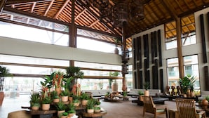 A spacious indoor area with multiple seating arrangements, potted plants, and large windows allowing natural light. - Samoa Beach Resort (Ipojuca)
