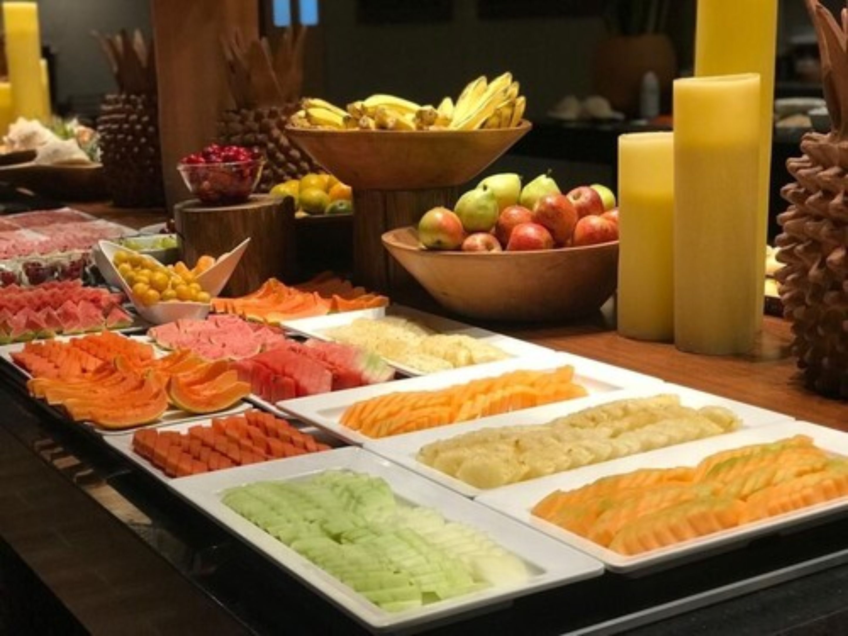 A buffet with various food items including fruits, vegetables, and meats.