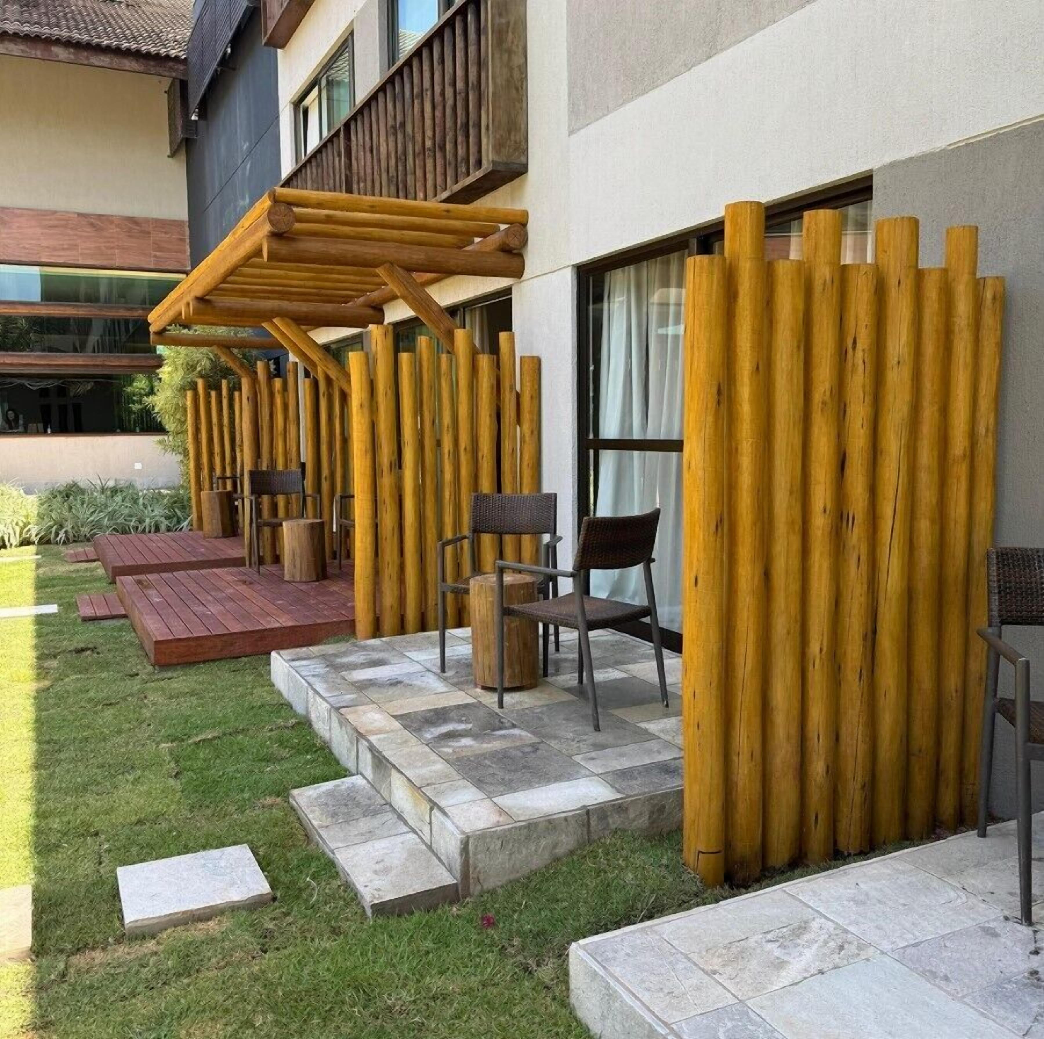 A modern outdoor seating area with wooden pergolas, stone steps, and outdoor furniture.