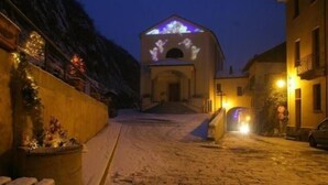 A snow-covered street leading to a building with a lit entrance. - b&b Vecchio Torchio (Bard)