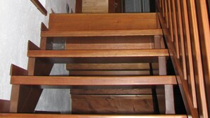 A wooden staircase with a wooden handrail and a small window at the top. - b&b Vecchio Torchio (Bard)