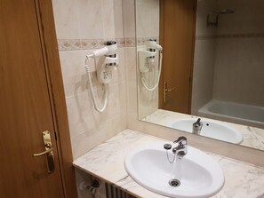 A bathroom with a marble sink, a handheld showerhead, and a bathtub. - Hotel Guineu (Pas de la Casa)