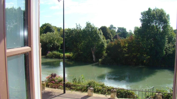 Vista de un río con árboles y una farola.