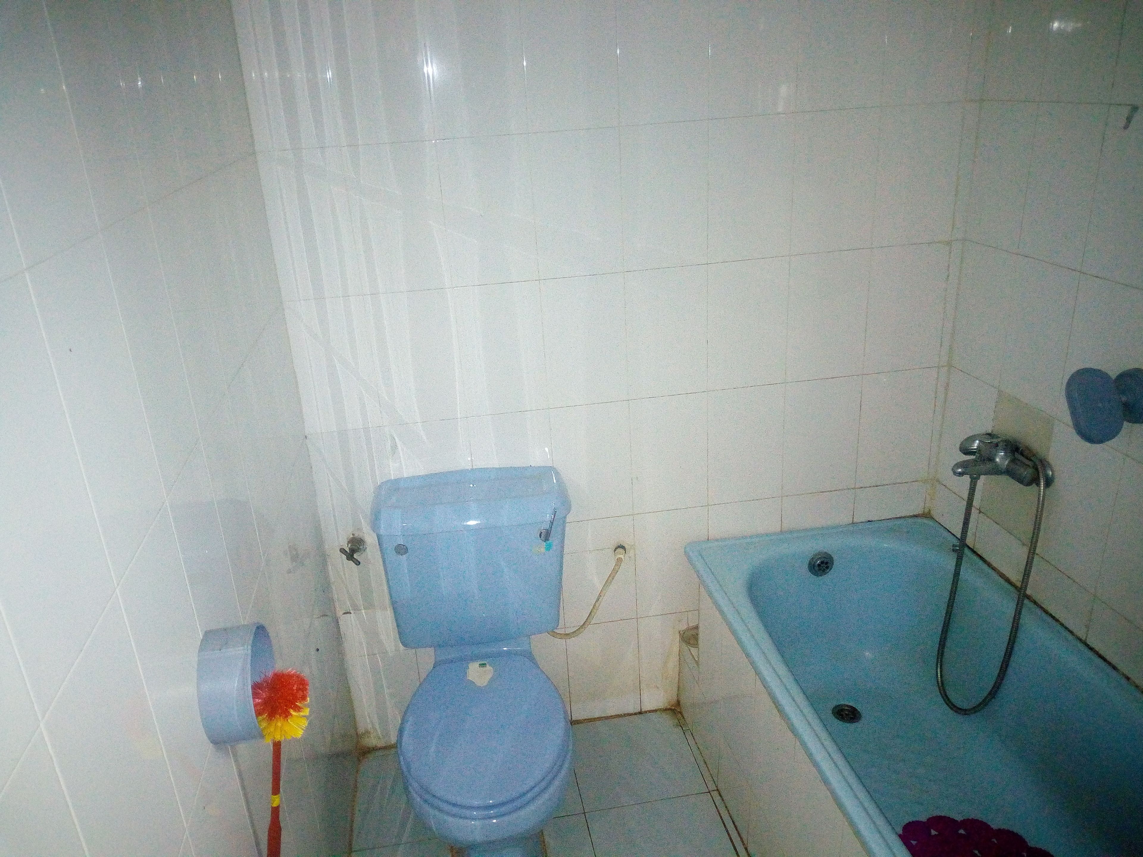 A bathroom with a toilet, a bathtub, and a shower.