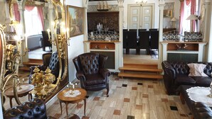 A luxurious room with ornate furniture, a grand mirror, and a dining area with a chandelier. - Gørdinglund Herregård Mainbuilding (Gording)