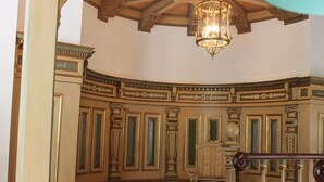 A room with ornate moldings, a chandelier, and a chair. - Gørdinglund Herregård Mainbuilding (Gording)