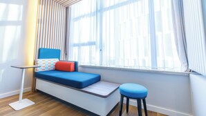 A modern room with a built-in bench seat, a small table, and a stool. - Holiday Inn Express Harbin Qunli by IHG (Harbin)