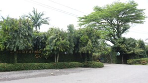 A paved road leading to a building with a sign that reads "Cacaranda Su." - Jacaranda Suites (Calabar)