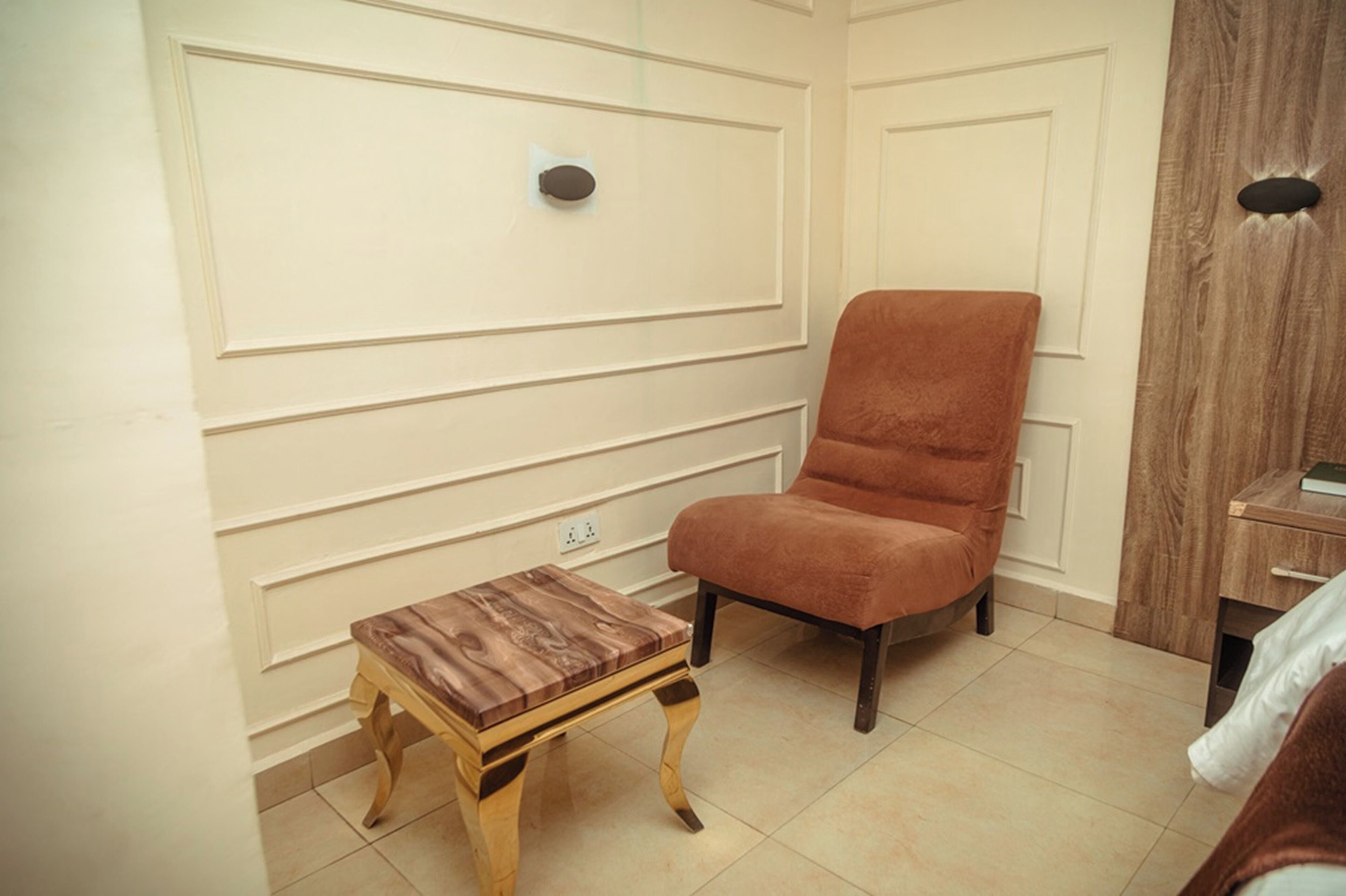 A room with a wooden table, a cushioned chair, and a wooden cabinet.