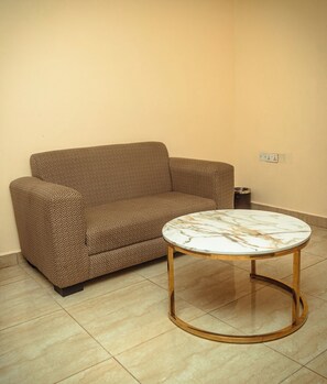 Una sala de estar con un sofá estampado y una mesa de centro de mármol.