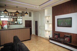 Ein modernes Wohnzimmer mit Bar, einem Wand-Fernseher und einer Musikanlage.