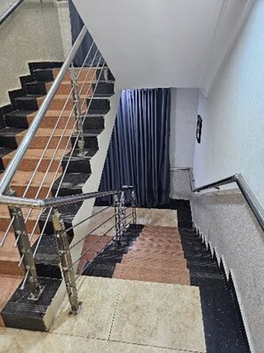 Una escalera con barandas metálicas y suelo estampado.