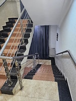 Una escalera con barandas metálicas y suelo estampado.
