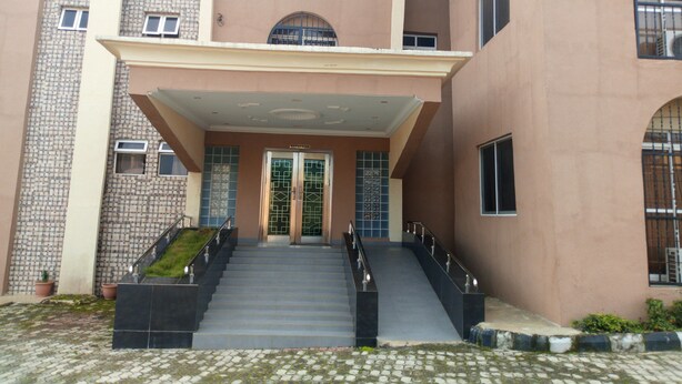 A building with a reception area, a staircase leading to the entrance, and a tiled ground. - Modroy Hotel and Suites (Abeokuta)