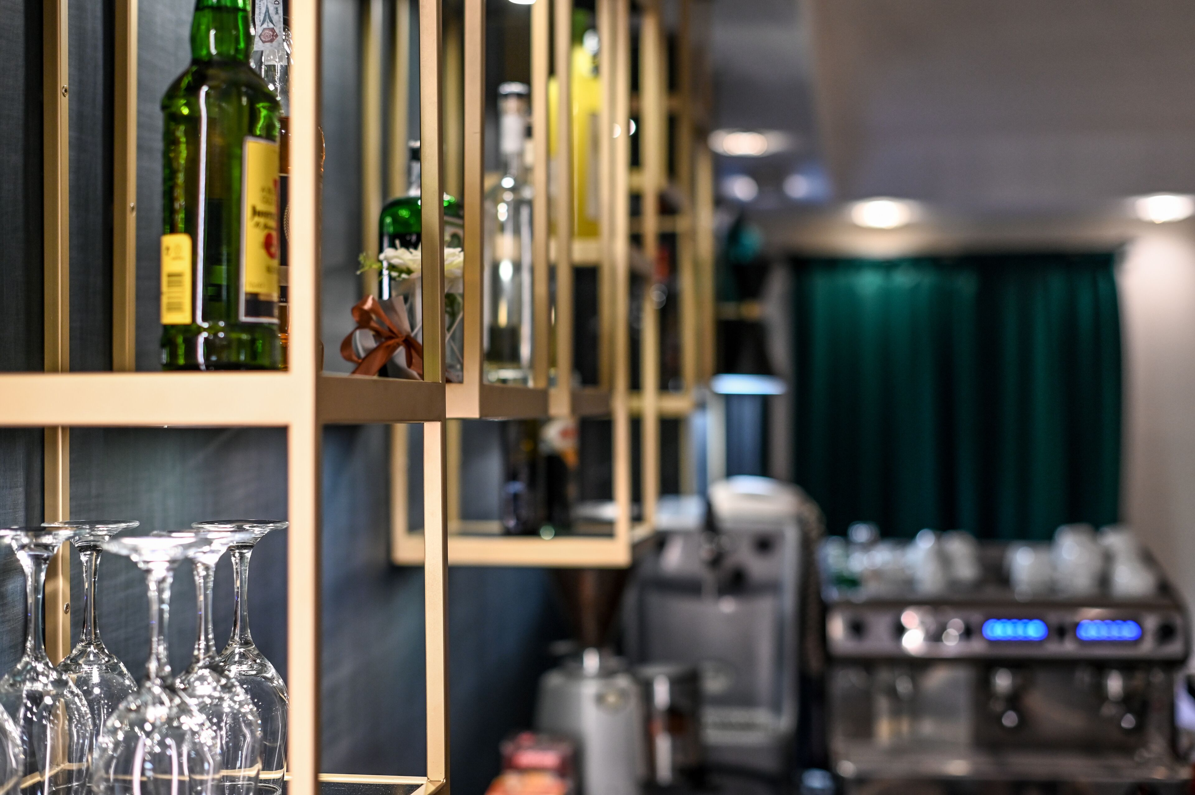 A bar area with shelves of bottles and glasses.
