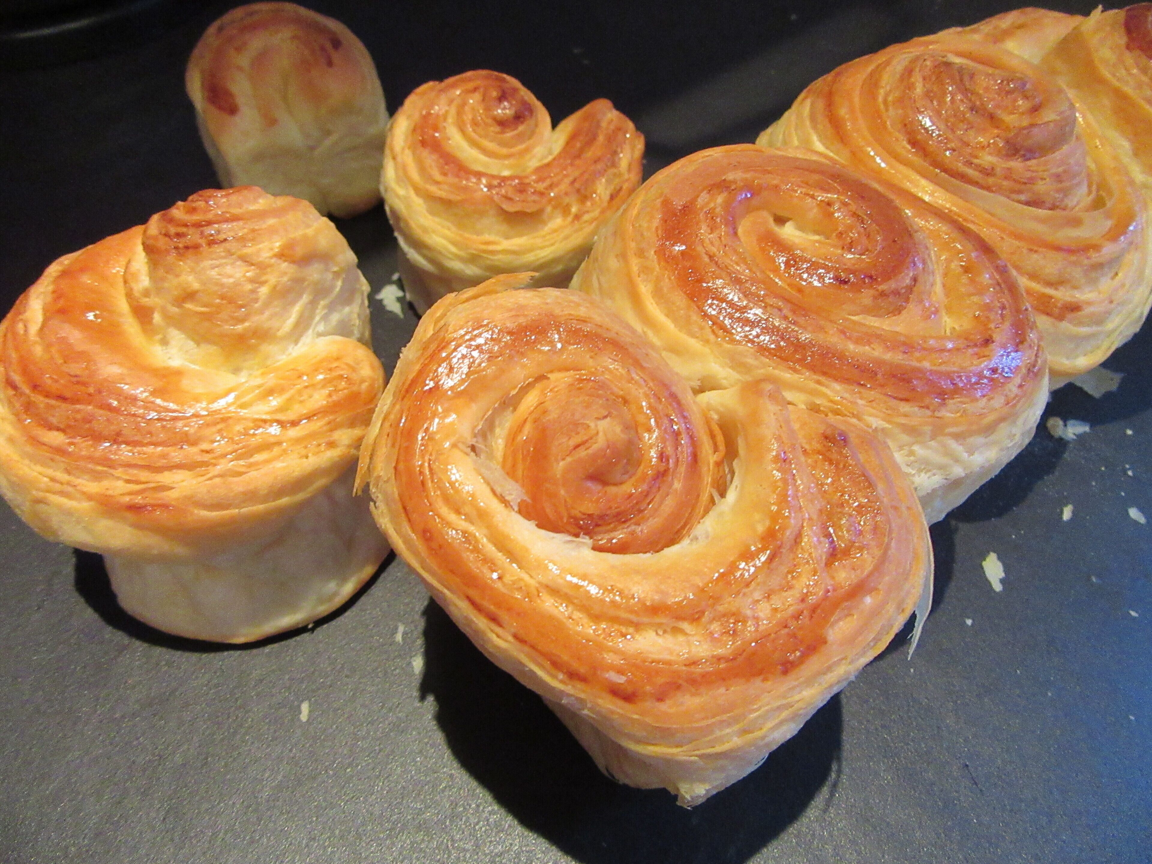 A close-up of freshly baked pastries with a golden-brown crust, likely a type of sweet roll or pastry.