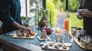 A table with various food items and drinks, including cookies, a glass of juice, and jars of preserves. - La Villa Dunois (Orléans)