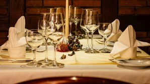 A table set for dining with a candle centerpiece, glasses, and a painting in the background. - Waldshuter Hof (Waldshut-Tiengen)
