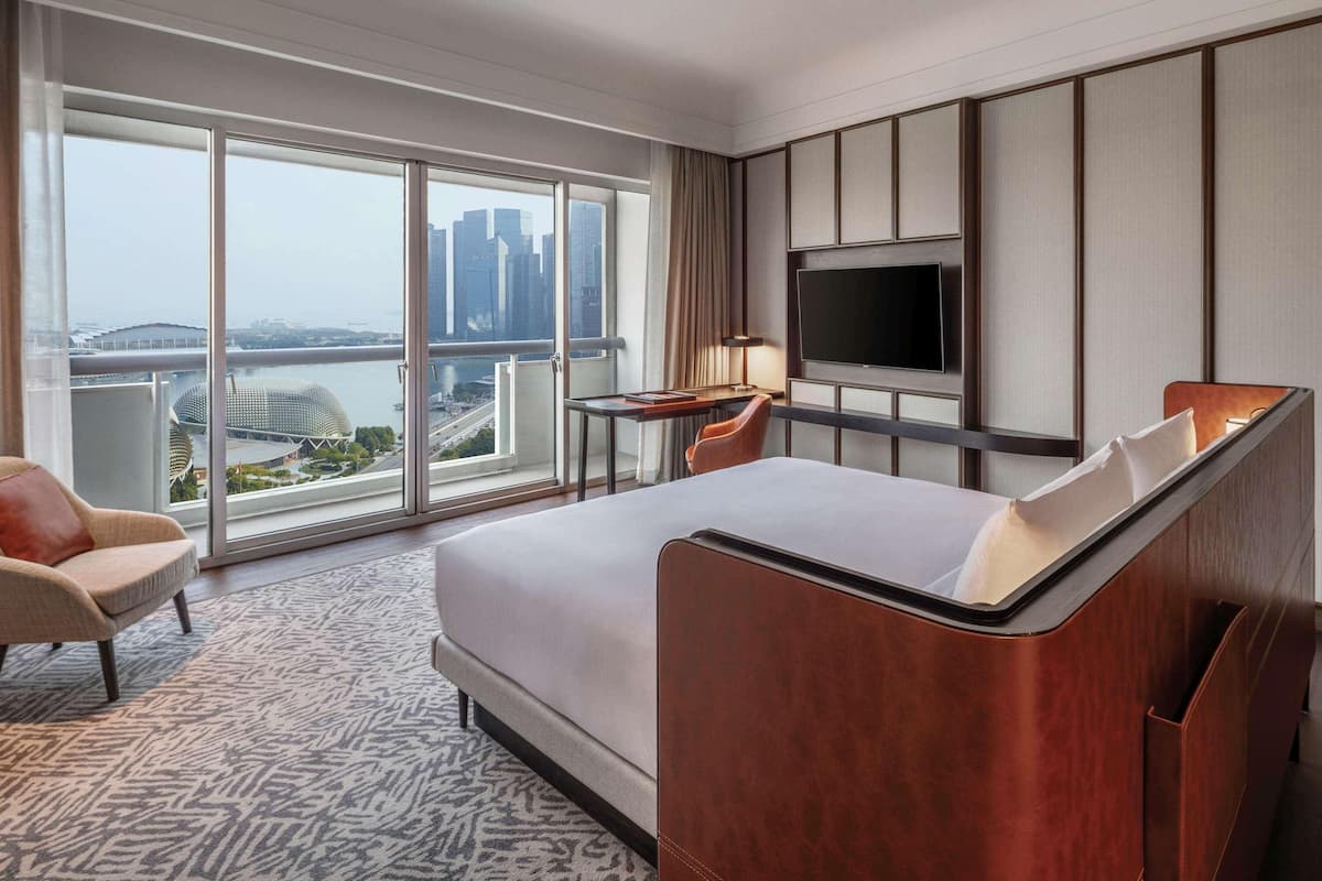 Een hotelkamer met een groot bed, een televisie, een bureau en een stoel.