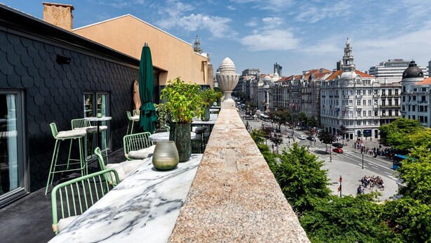 A terrace with outdoor seating, a view of the cityscape, and a prominent dome structure in the distance. - One Shot Aliados Goldsmith  (Porto)