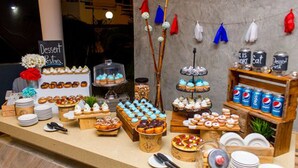 Ein Dessertbuffet mit verschiedenen Kuchen und Süßspeisen auf einer Holztischplatte.