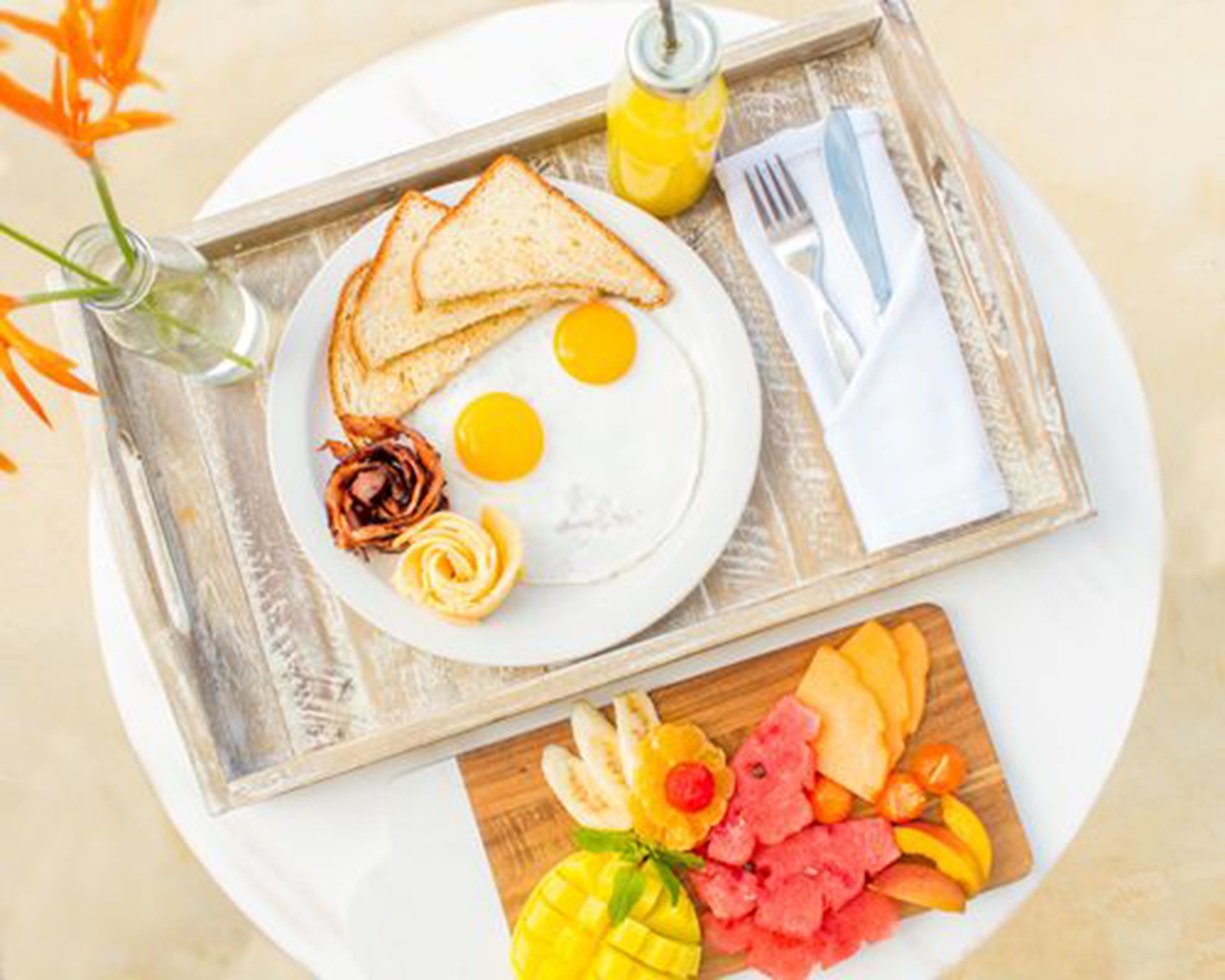 A breakfast tray with toast, eggs, and a selection of fruits and vegetables.