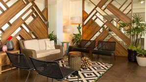 A modern living room with a geometric wooden partition, a sofa, two armchairs, a coffee table, and a lamp. - LD Plus (Paraguachí)