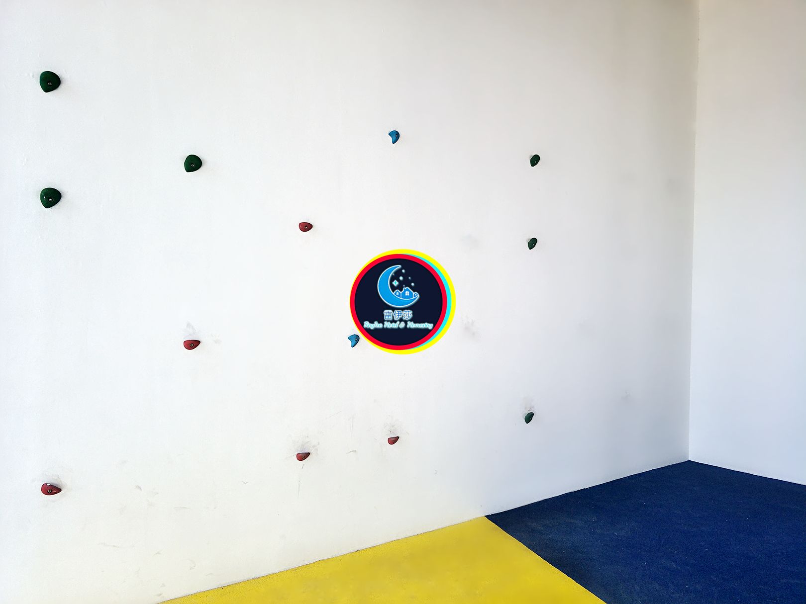 Una habitación con una pared blanca que presenta un logo circular y varios punzones de colores.