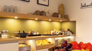 A breakfast buffet with various food items and utensils. - De Vlindertuin Ameland (Nes)