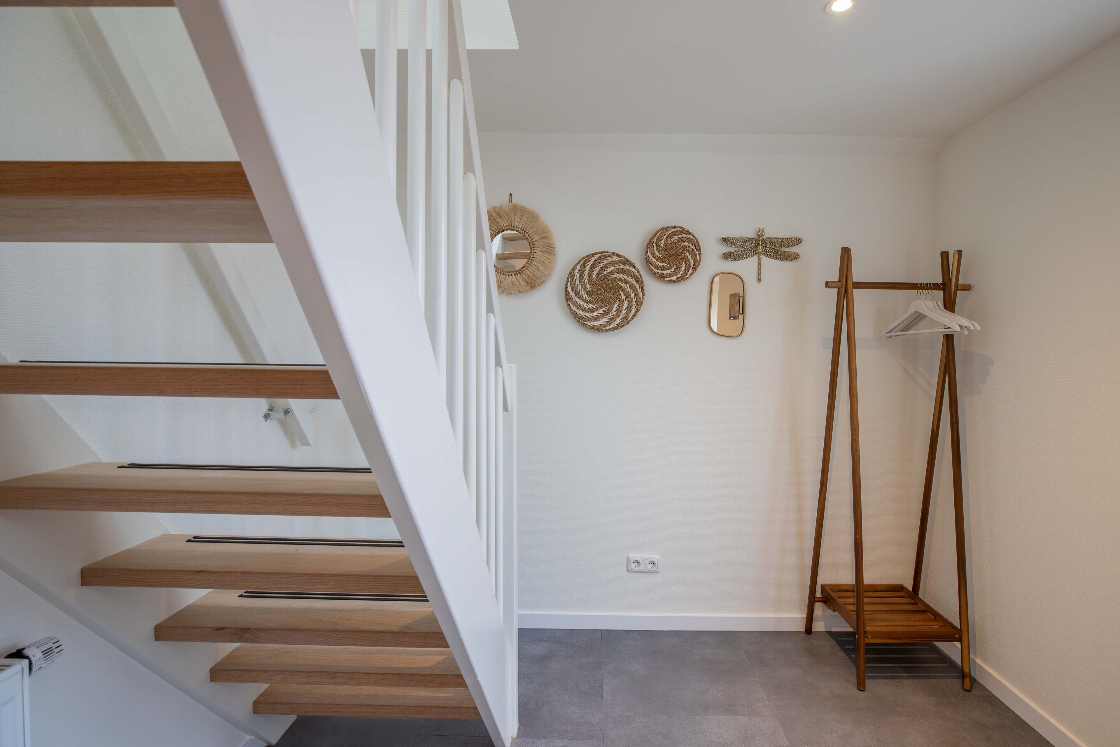 A modern staircase with wooden steps and white walls.