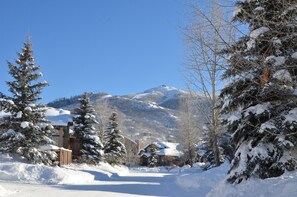 A snow-covered mountain landscape with a lodge in the foreground. - Cascades at Steamboat (Steamboat Springs)